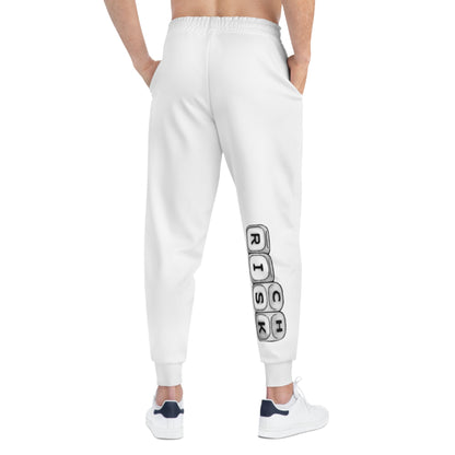 White athletic joggers by x-streets with bold “RISK” leg print – tapered unisex fit, sublimation print, made for fearless streetwear statements.
